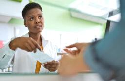 Female pharmacist talking with customer